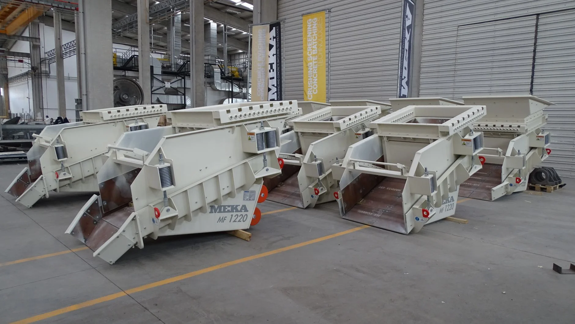 Row of industrial vibrating screens assembled for mineral and aggregate processing