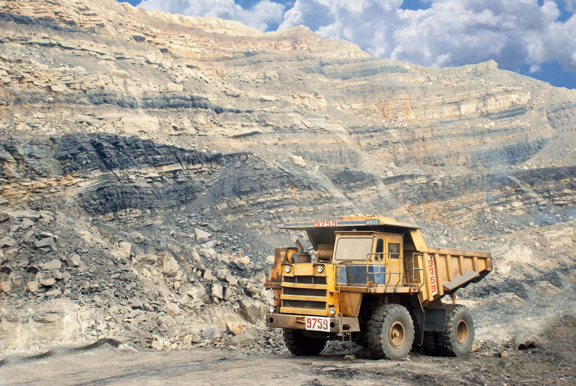Haul truck in an open-pit mine where abrasive ore is processed and screened