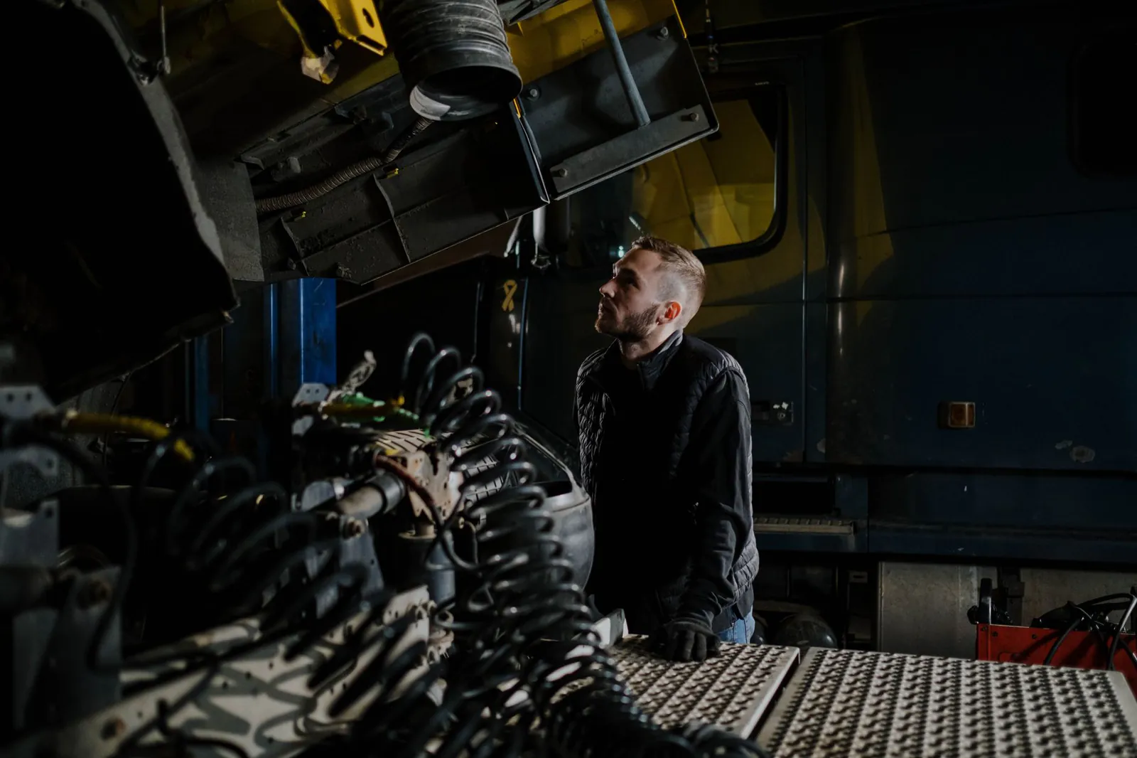 Technician inspecting heavy industrial equipment in a Canadian workshop
